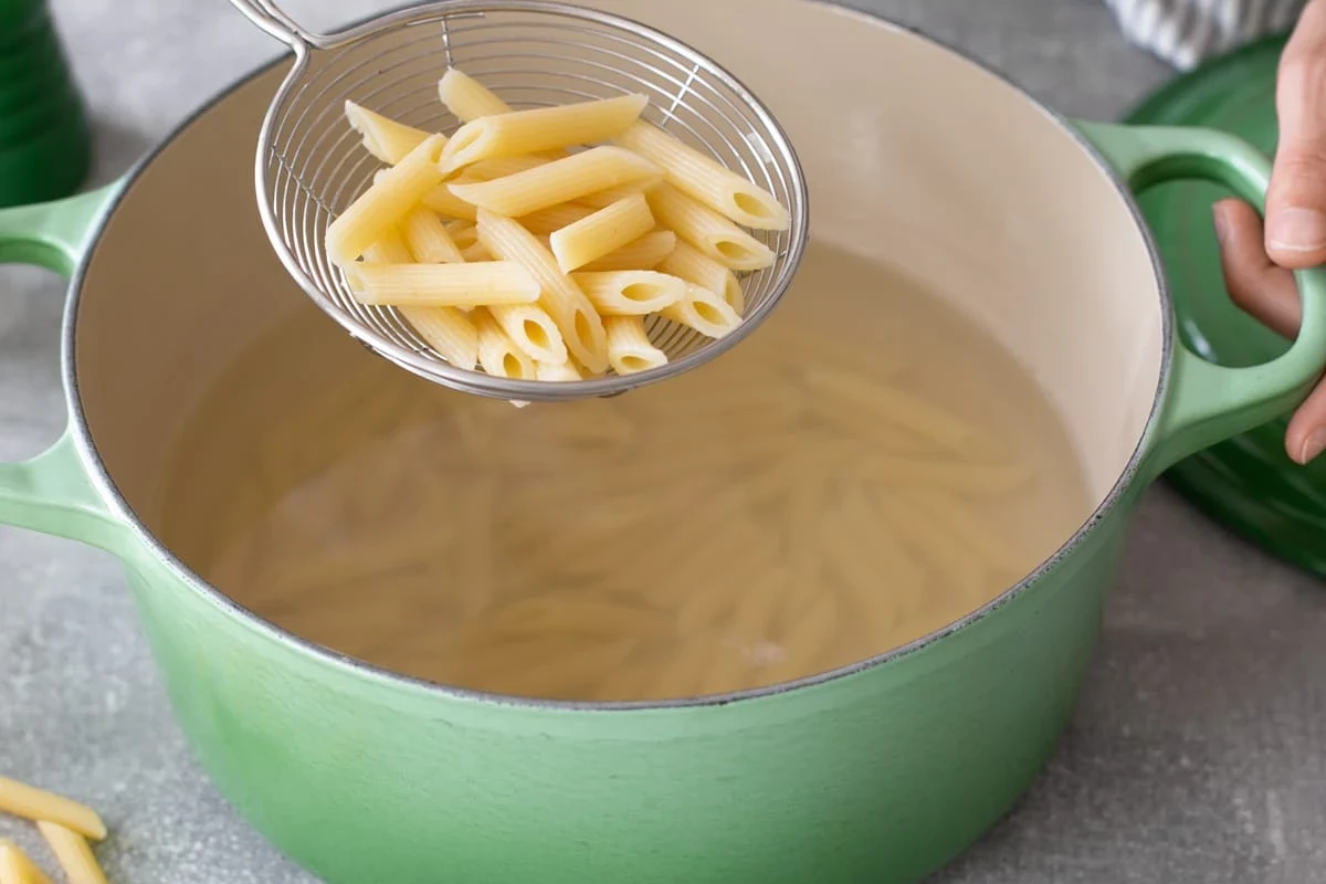 Bowl of al dente pasta with sauce in a bright home kitchen