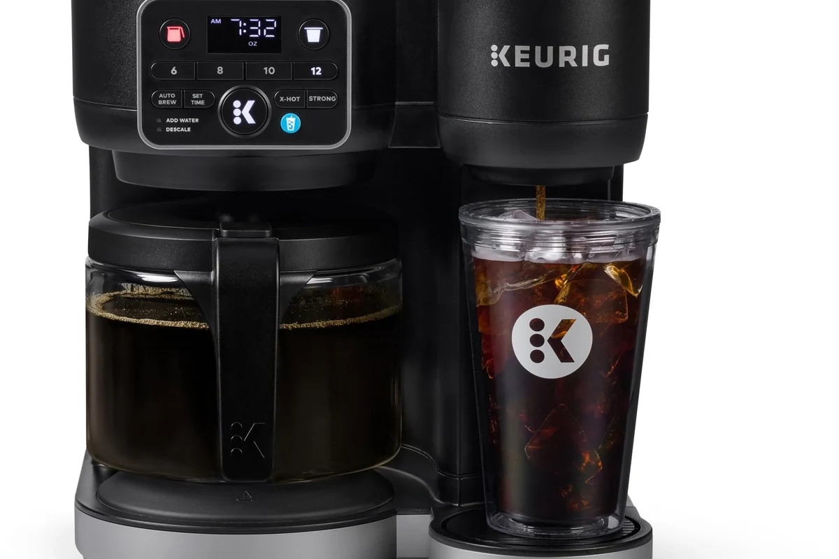 French press coffee maker with grounds, hot water, and a plunger on a kitchen counter