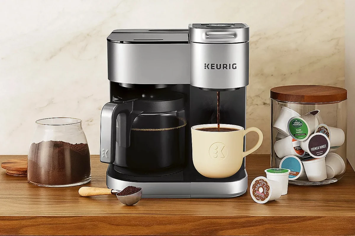 French press coffee in a glass press with coarse grounds and a mug on a kitchen counter