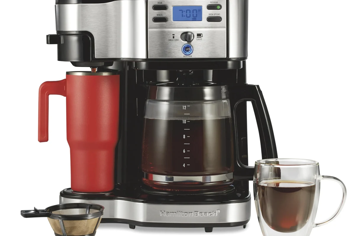 French press coffee setup with grounds, kettle, and press on a kitchen counter