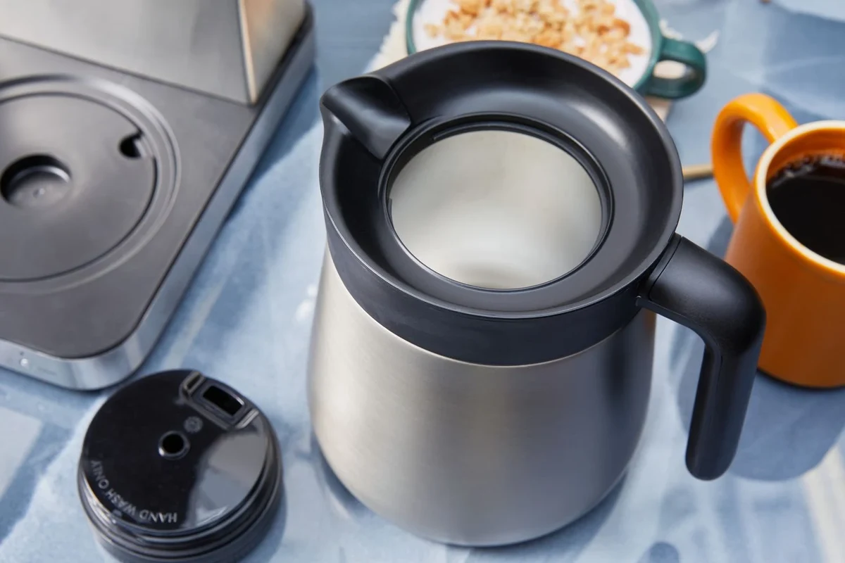 French press coffee maker with brewed coffee, grounds, and simple kitchen setup