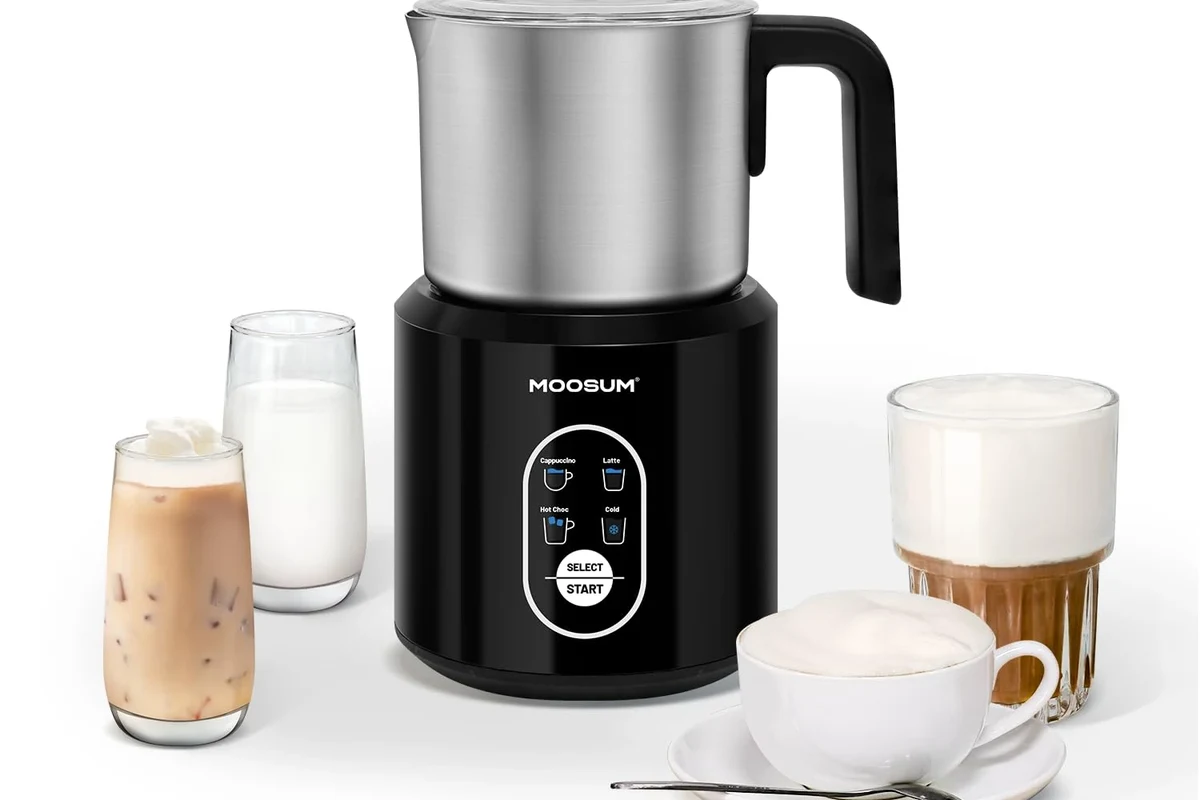 Electric milk frother being cleaned with warm water, soap, and a soft sponge in a kitchen sink