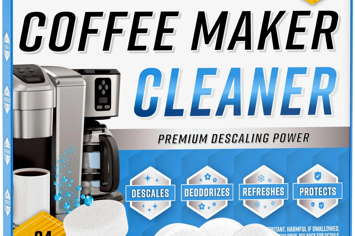 Keurig cold brew coffee maker being descaled with cleaning solution and a mug nearby