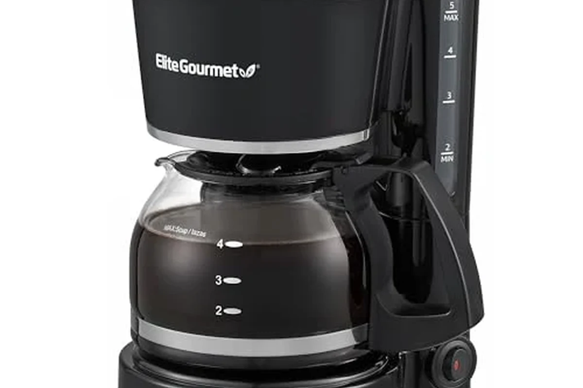 French press coffee maker with coarse grounds, hot water, and a fresh cup on a kitchen counter