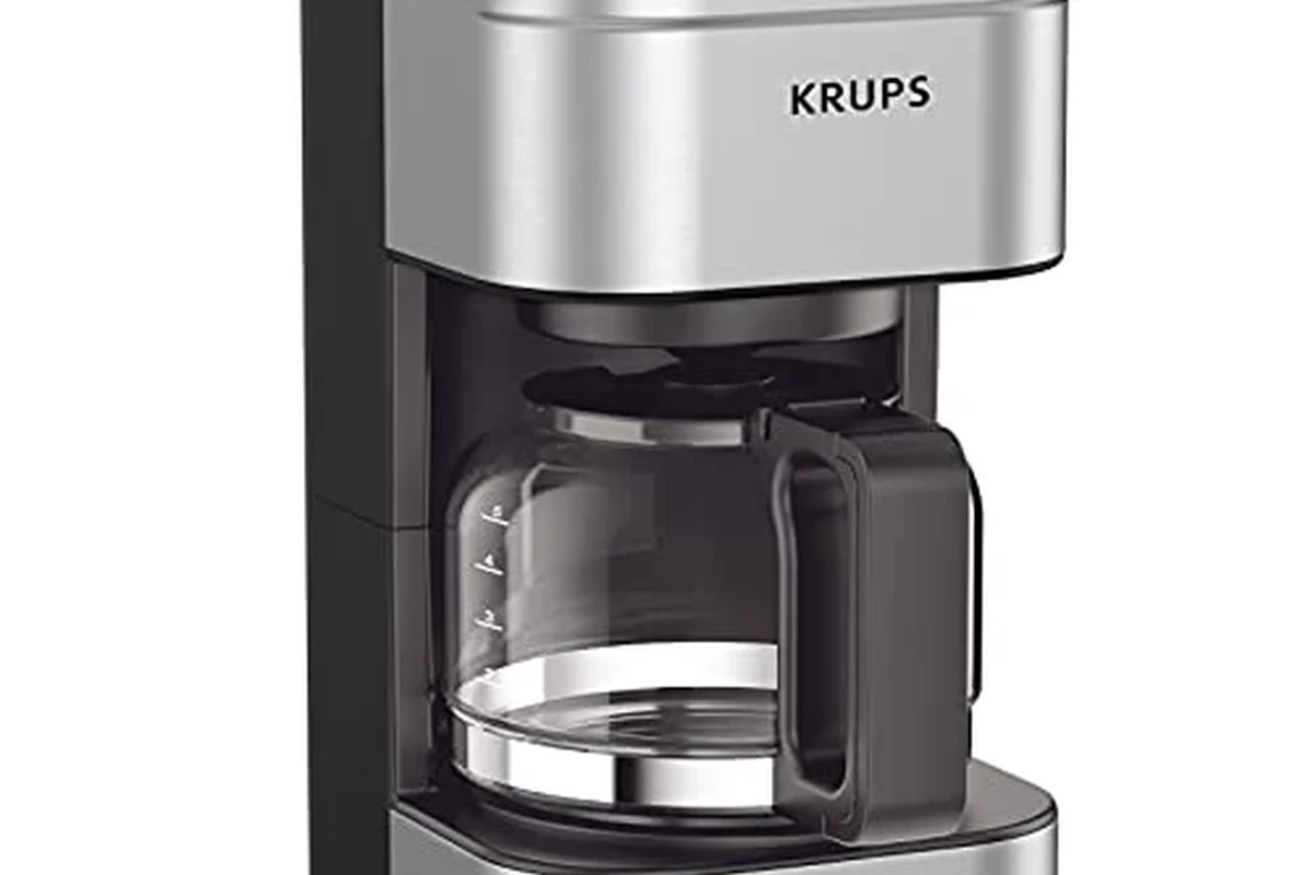 French press coffee maker with grounds, kettle, and measuring tools on a kitchen counter