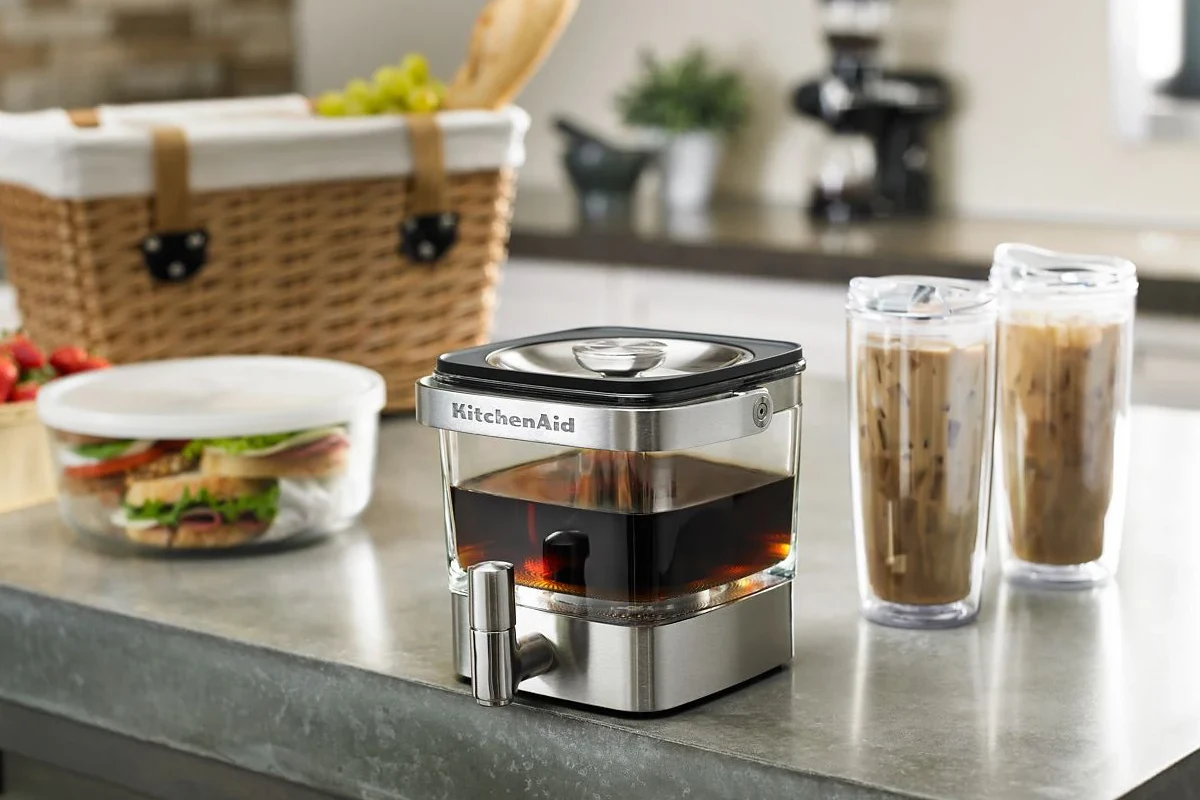 French press coffee maker with grounds, hot water, and a brewing setup in a home kitchen