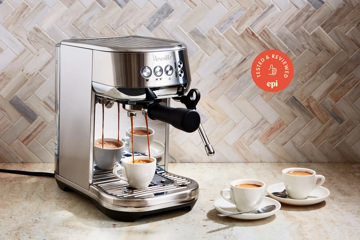 French press coffee maker with grounds, hot water, and plunger on a kitchen counter
