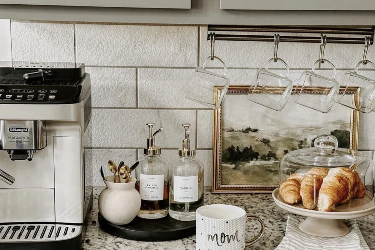 French press coffee makers in glass and stainless steel with coffee brewing tools on a kitchen counter
