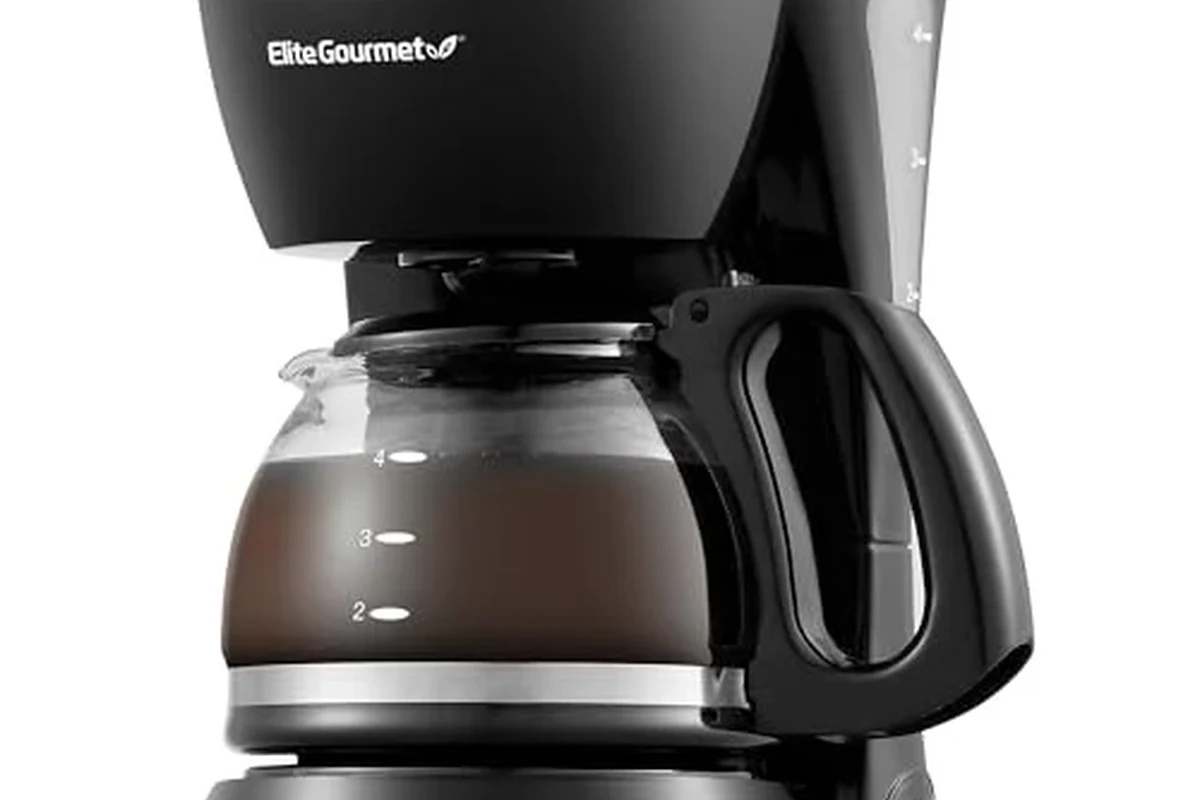 French press coffee maker with grounds, hot water, and plunger on a kitchen counter