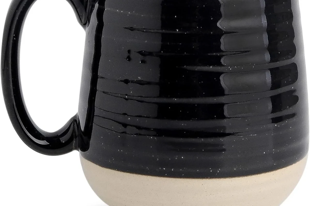 Coffee mugs in different materials and sizes arranged on a home kitchen counter