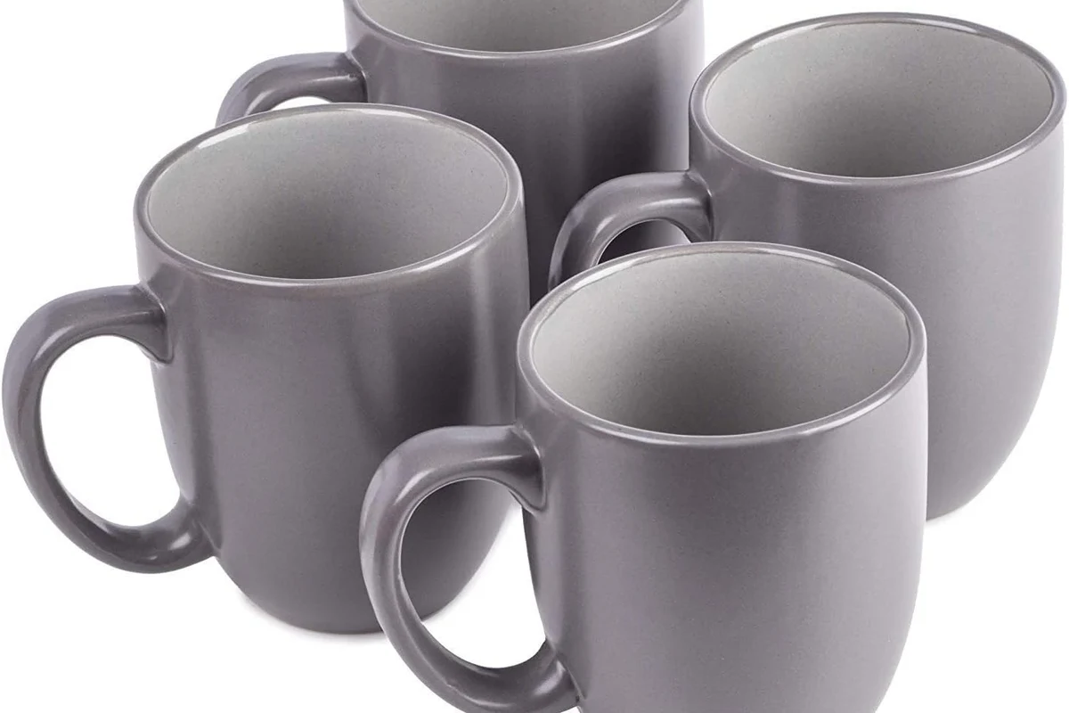 Coffee mugs in different materials and sizes arranged on a home kitchen counter