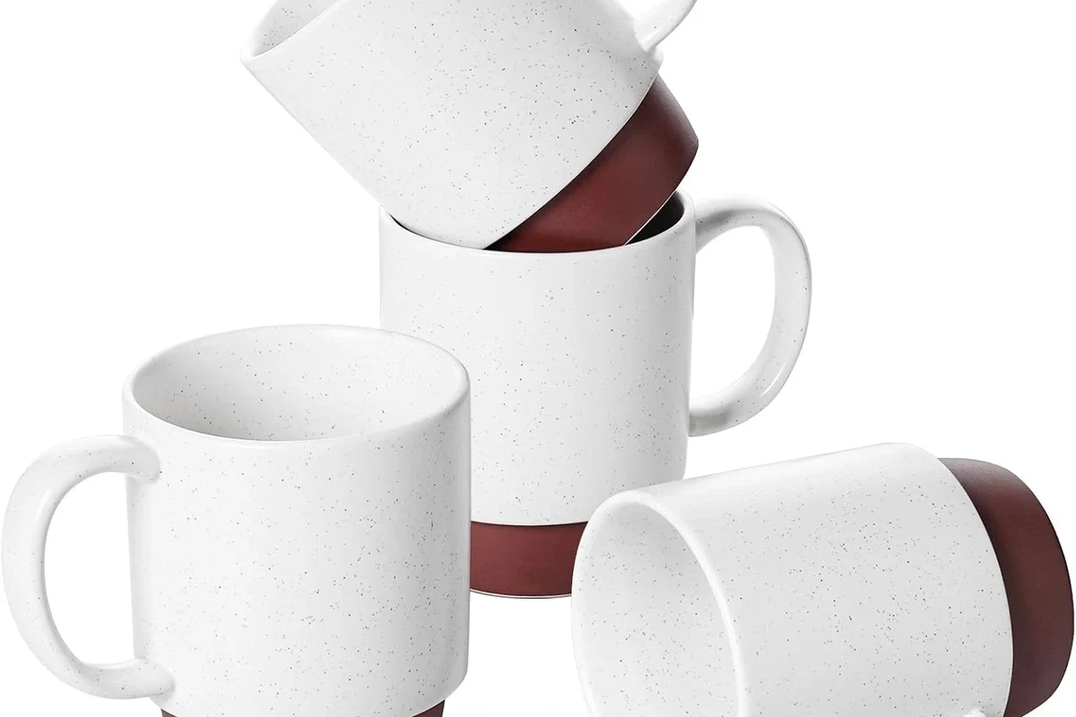 Assorted coffee mugs in ceramic, glass, porcelain, and stainless steel on a kitchen counter