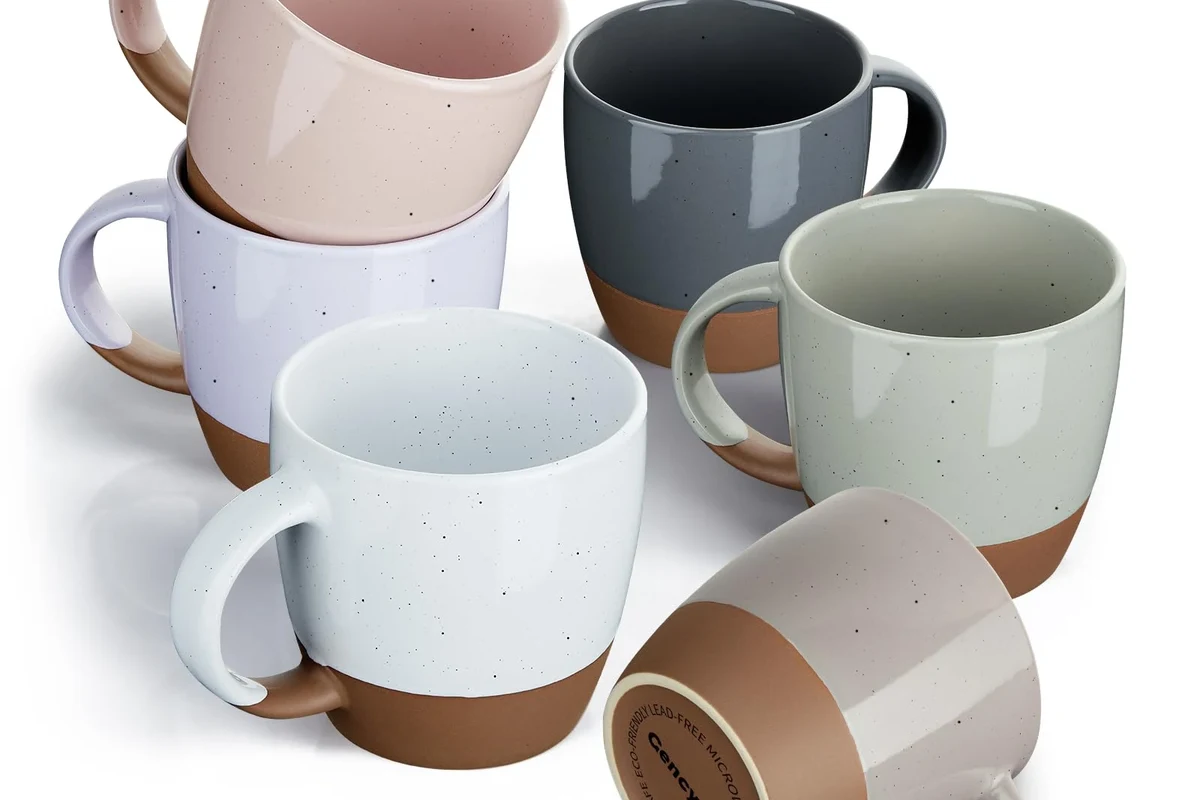 Ceramic coffee mug beside a fresh cup of black coffee on a kitchen counter