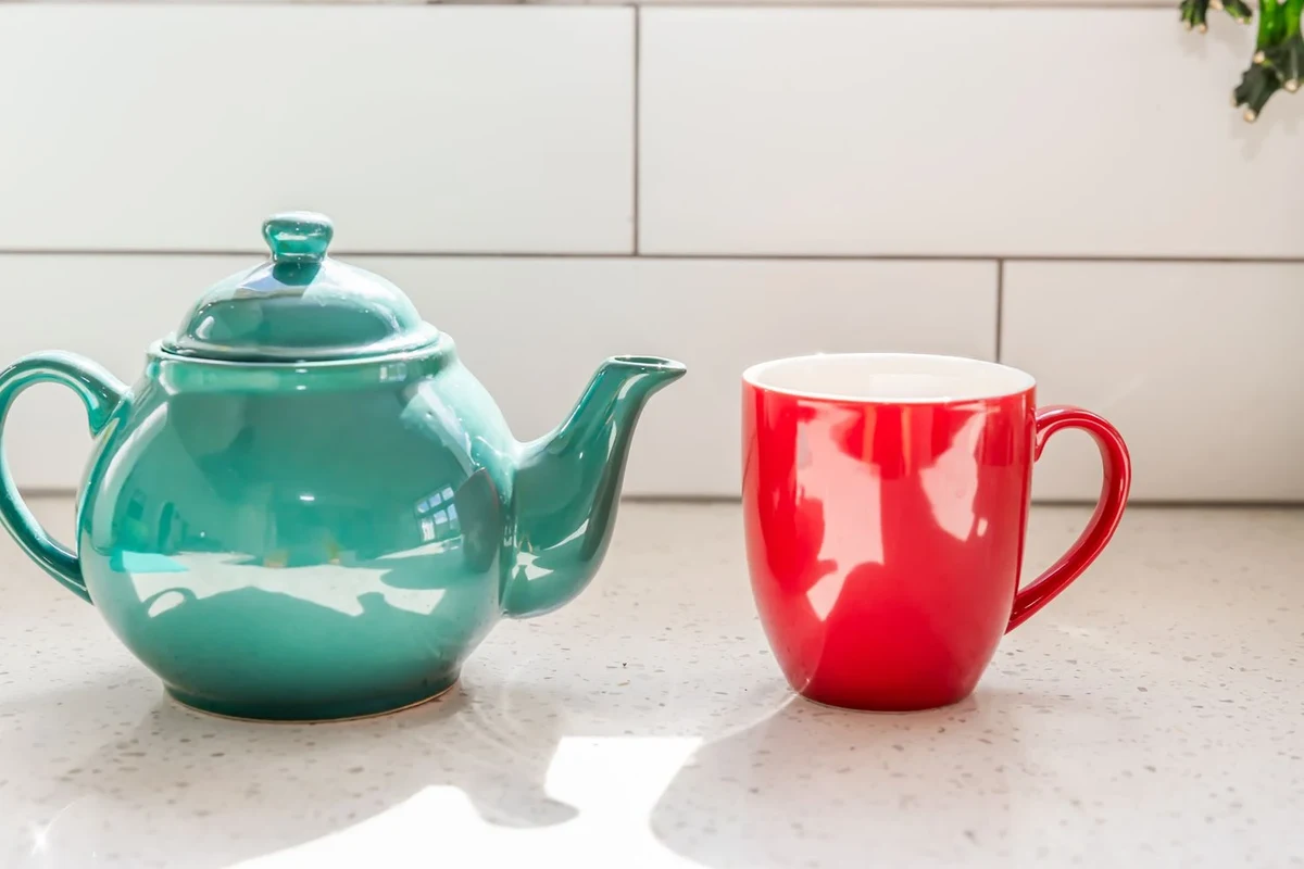 Ceramic coffee mugs on a kitchen counter with one chipped mug for safety context