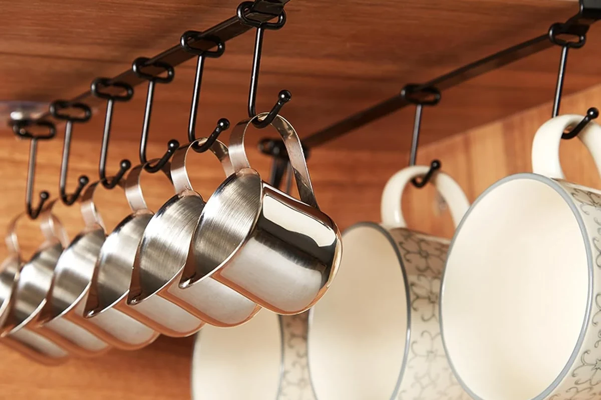 Coffee mugs arranged on a dishwasher bottom rack with one mug on the top rack