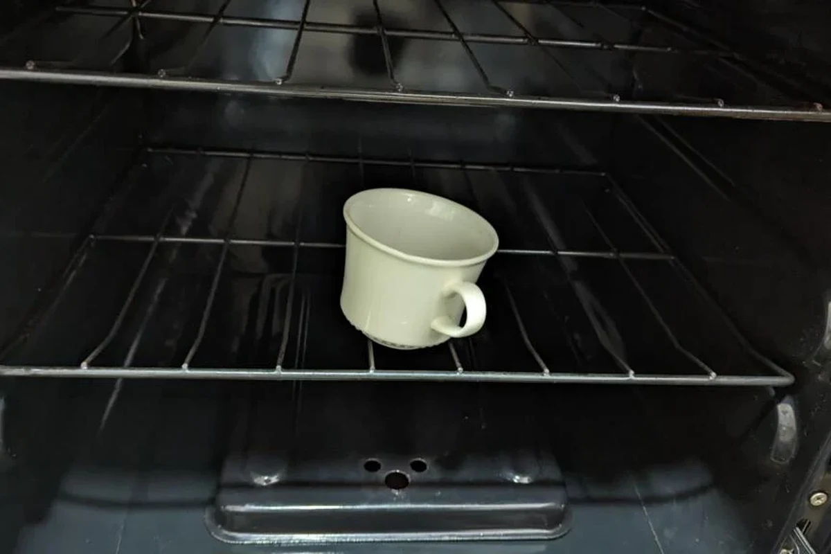 Coffee mug on a baking sheet inside an oven for safe small-batch baking