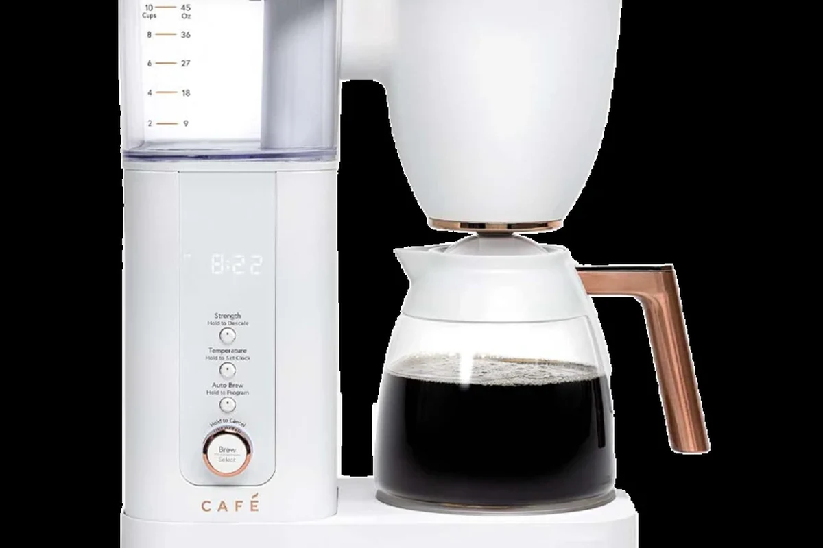 Bodum French press with coffee grounds, hot water, and a mug on a kitchen counter