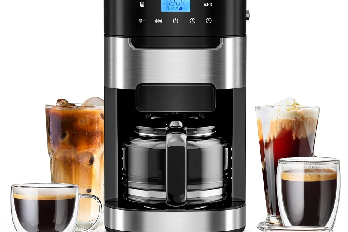 French press coffee in a glass press with coarse grounds and a mug on a kitchen counter