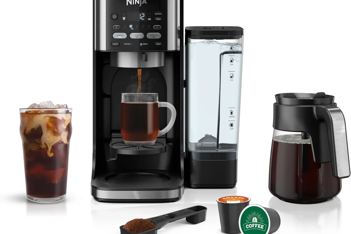 French press coffee maker with grounds, hot water, and a plunger on a kitchen counter