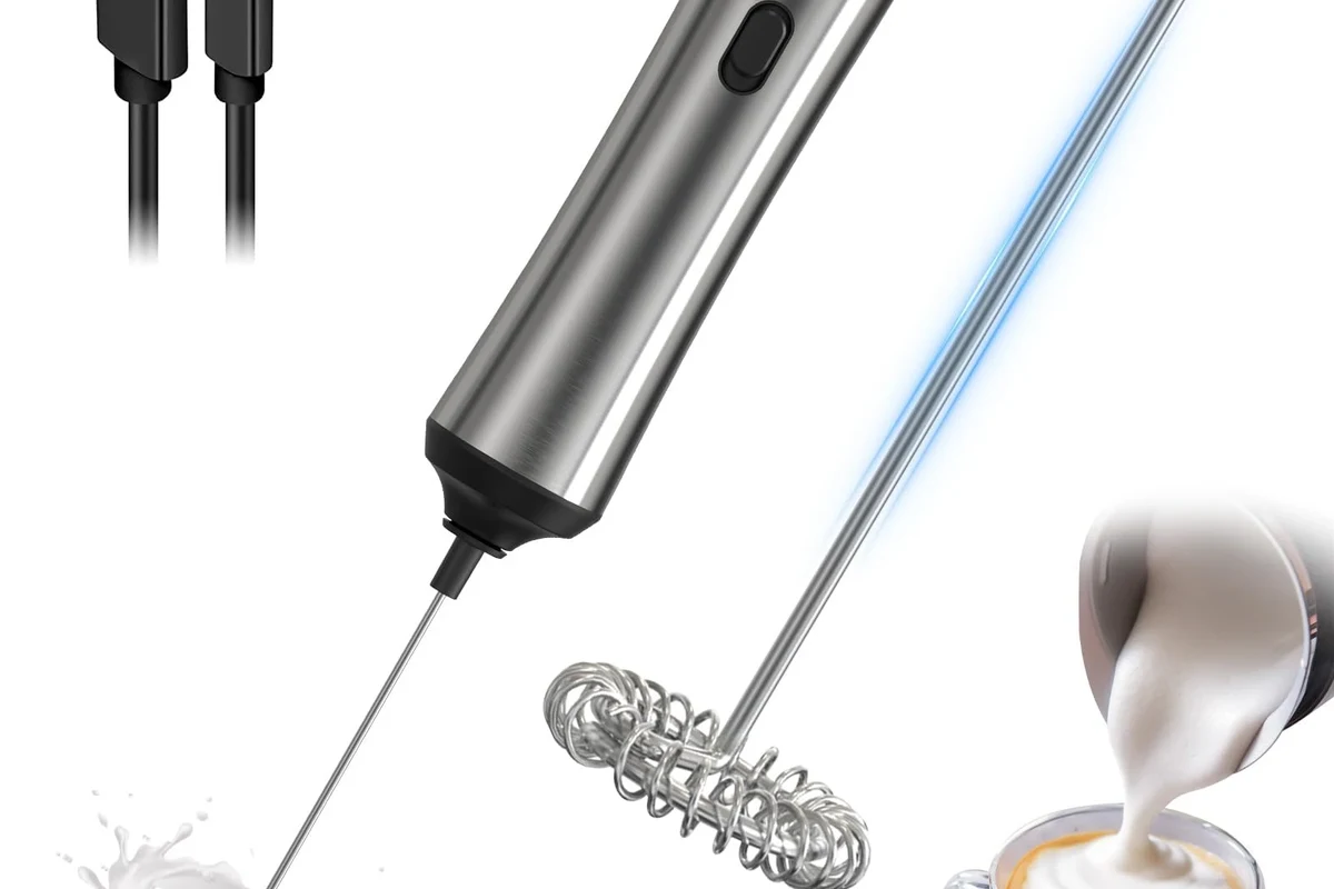 Electric milk frother making hot foam for coffee on a kitchen counter