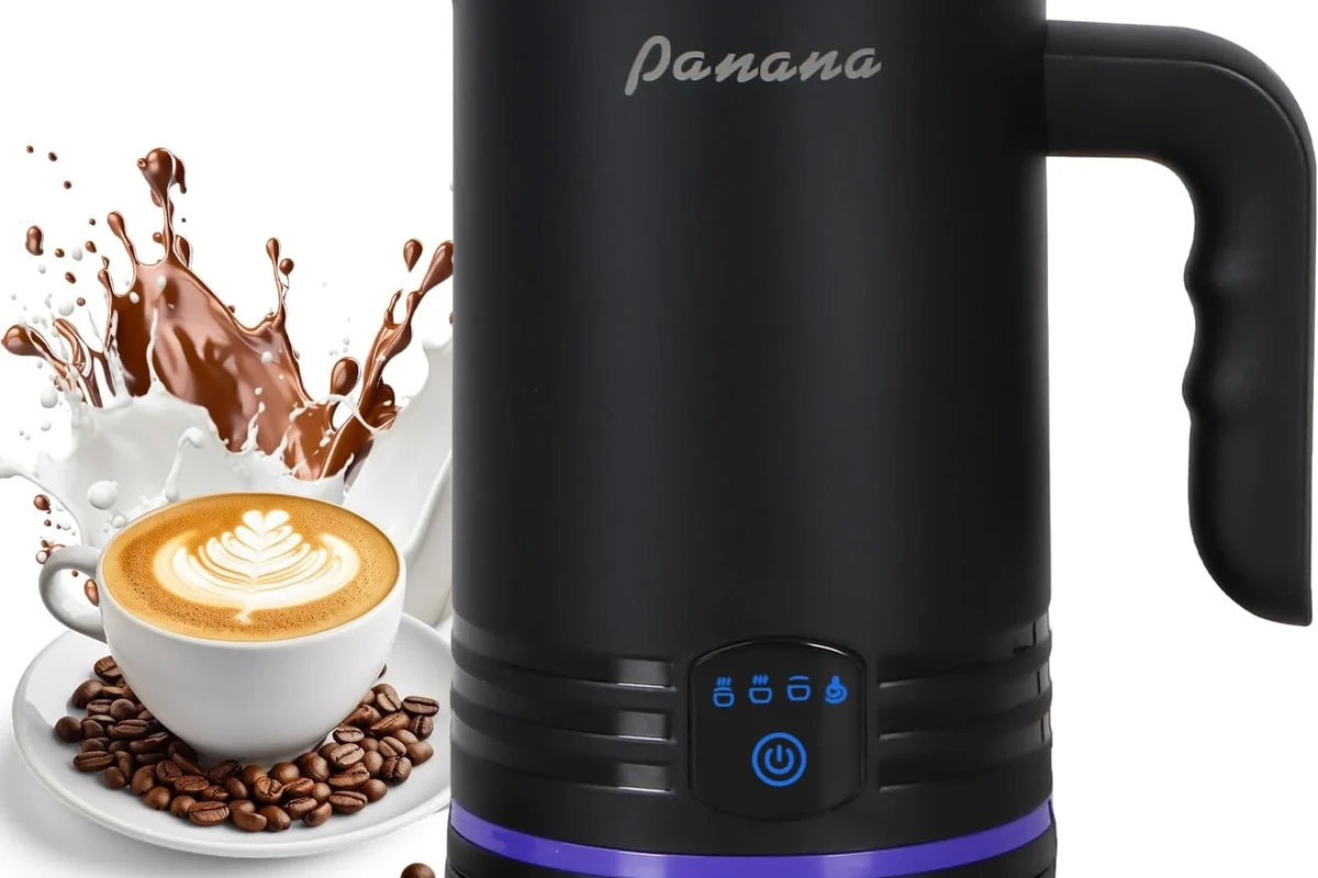 Electric milk frother making creamy foam in a kitchen beside a coffee mug