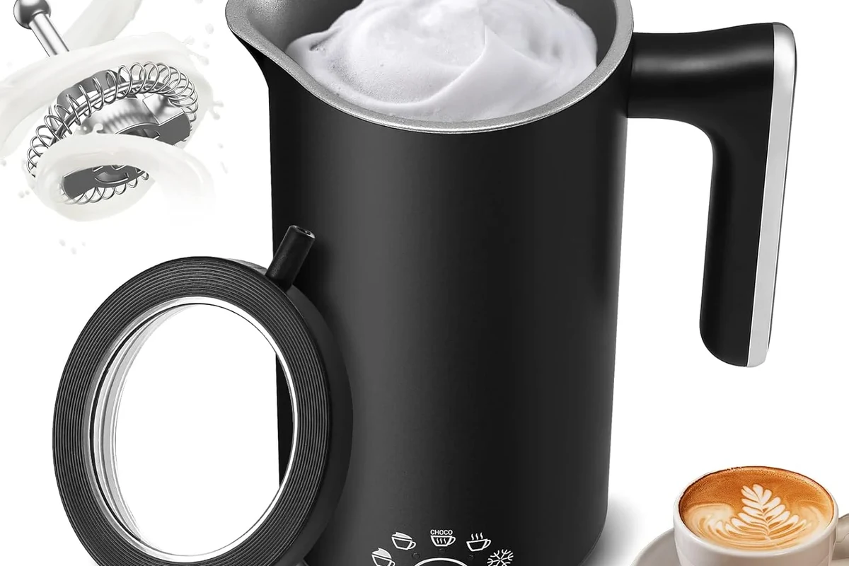 Electric milk frother whisking milk into foam in a home kitchen mug