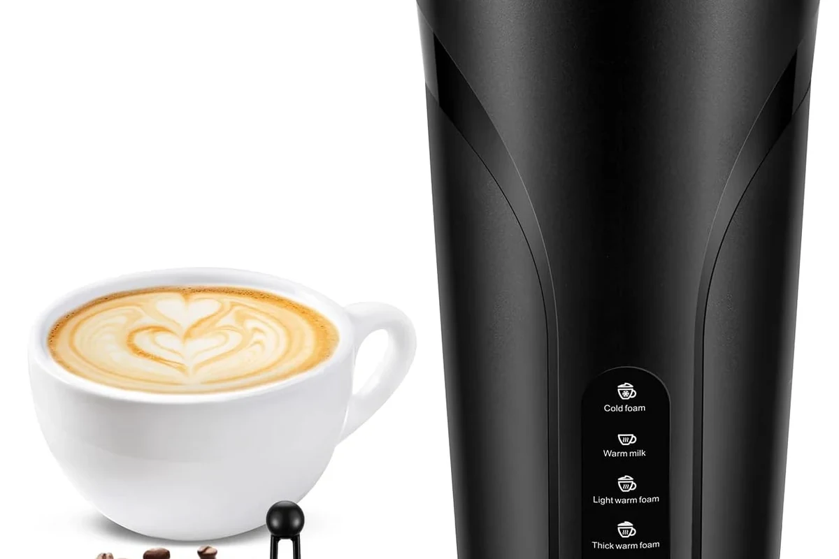 Electric milk frother whisking milk into creamy foam in a modern kitchen