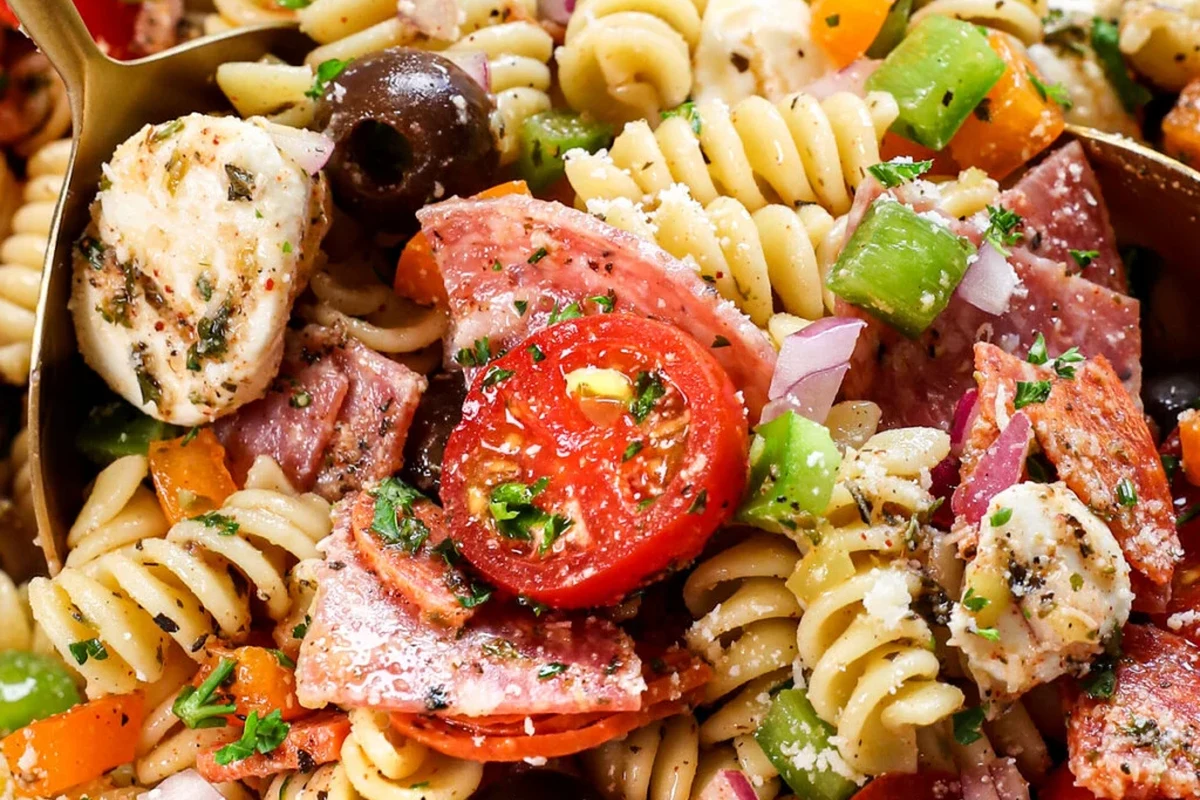 Bowl of pasta salad with sturdy pasta, vegetables, and a freezer storage container