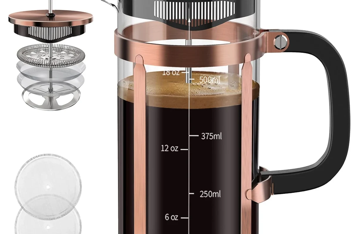 French press coffee maker with coarse grounds, hot water, and a kitchen counter setup