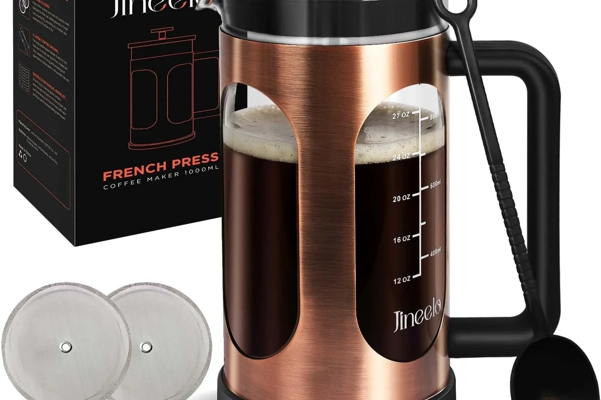 French press coffee maker with coffee grounds, hot water, and a plunger on a kitchen counter
