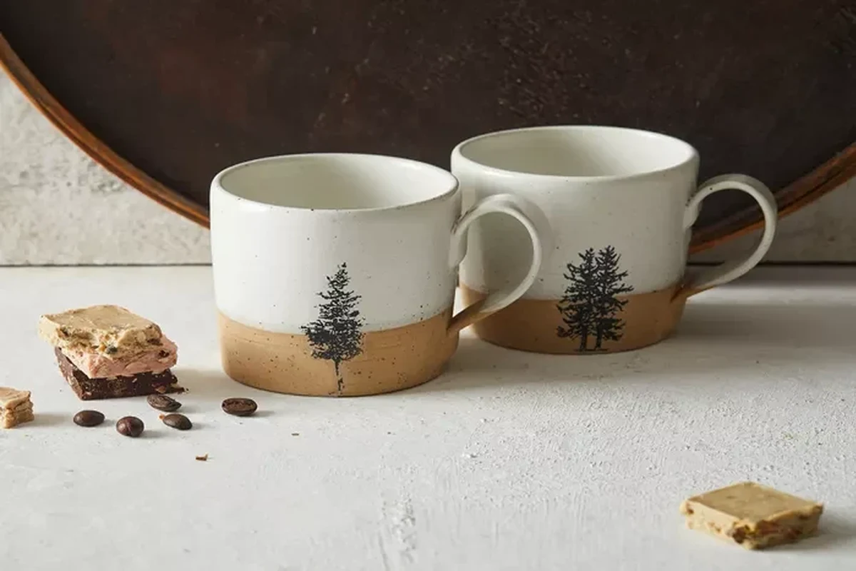 Vintage and modern coffee mugs arranged to show the history of mug design
