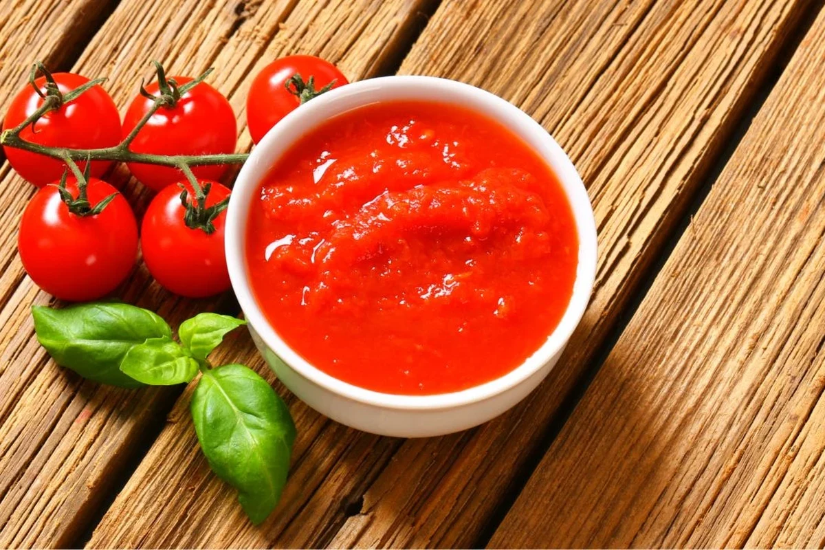 Bowls of tomato sauce, puree, canned tomatoes, and ketchup as tomato paste substitutes