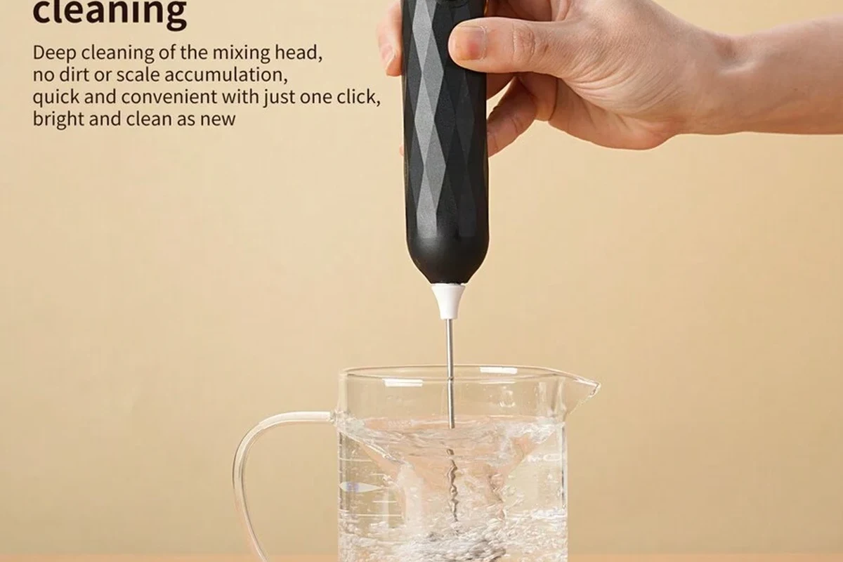 Electric milk frother making smooth cafe style foam in a kitchen mug