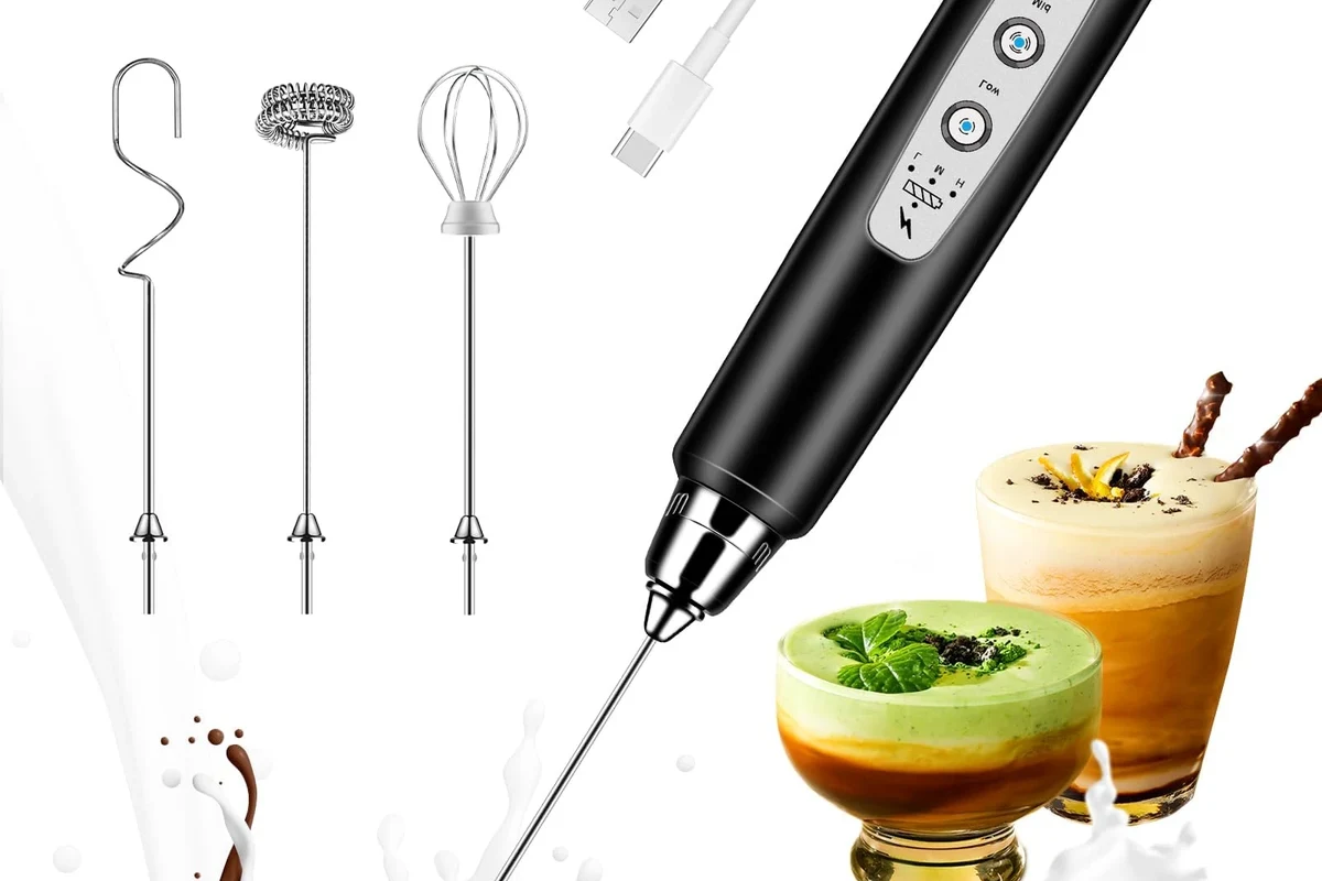 Electric milk frother making foamy milk for a homemade latte in a kitchen mug
