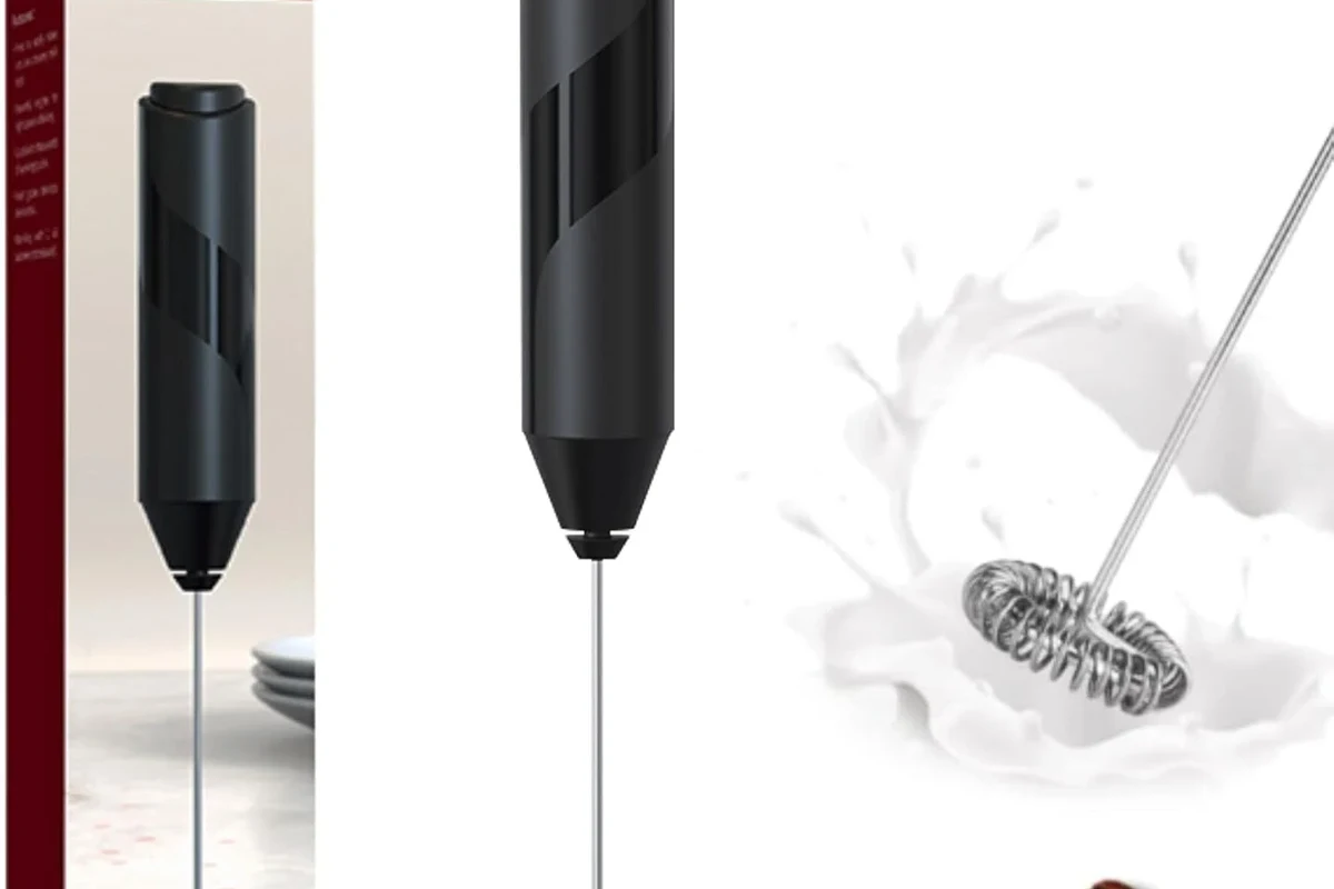 Electric milk frother making foamy milk for a homemade latte in a kitchen mug