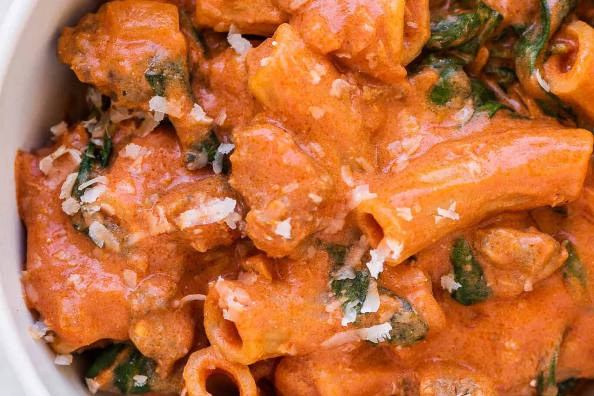 Pasta with Italian sausage in a skillet with tomato sauce and herbs