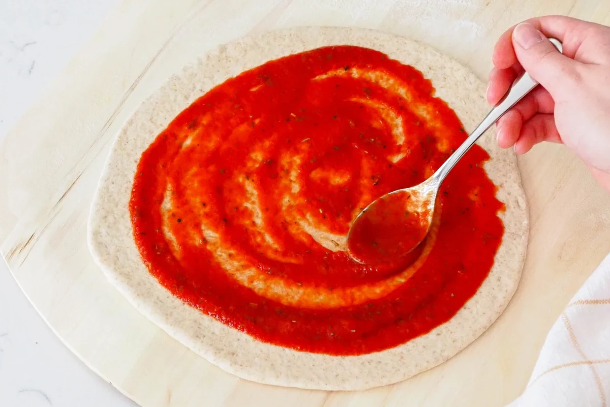 Bowl of homemade pizza sauce made from tomato paste with herbs and olive oil