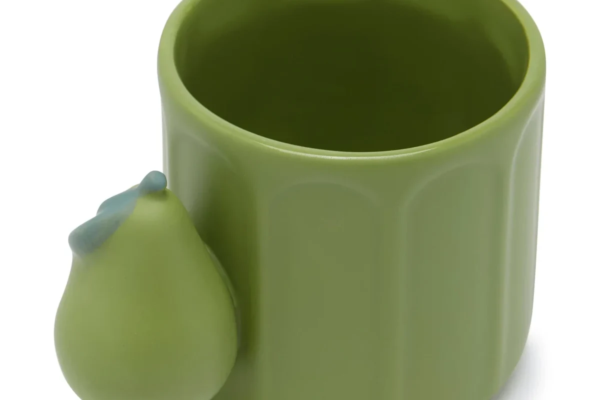 Ceramic coffee mug on an oven rack with a simple kitchen setup