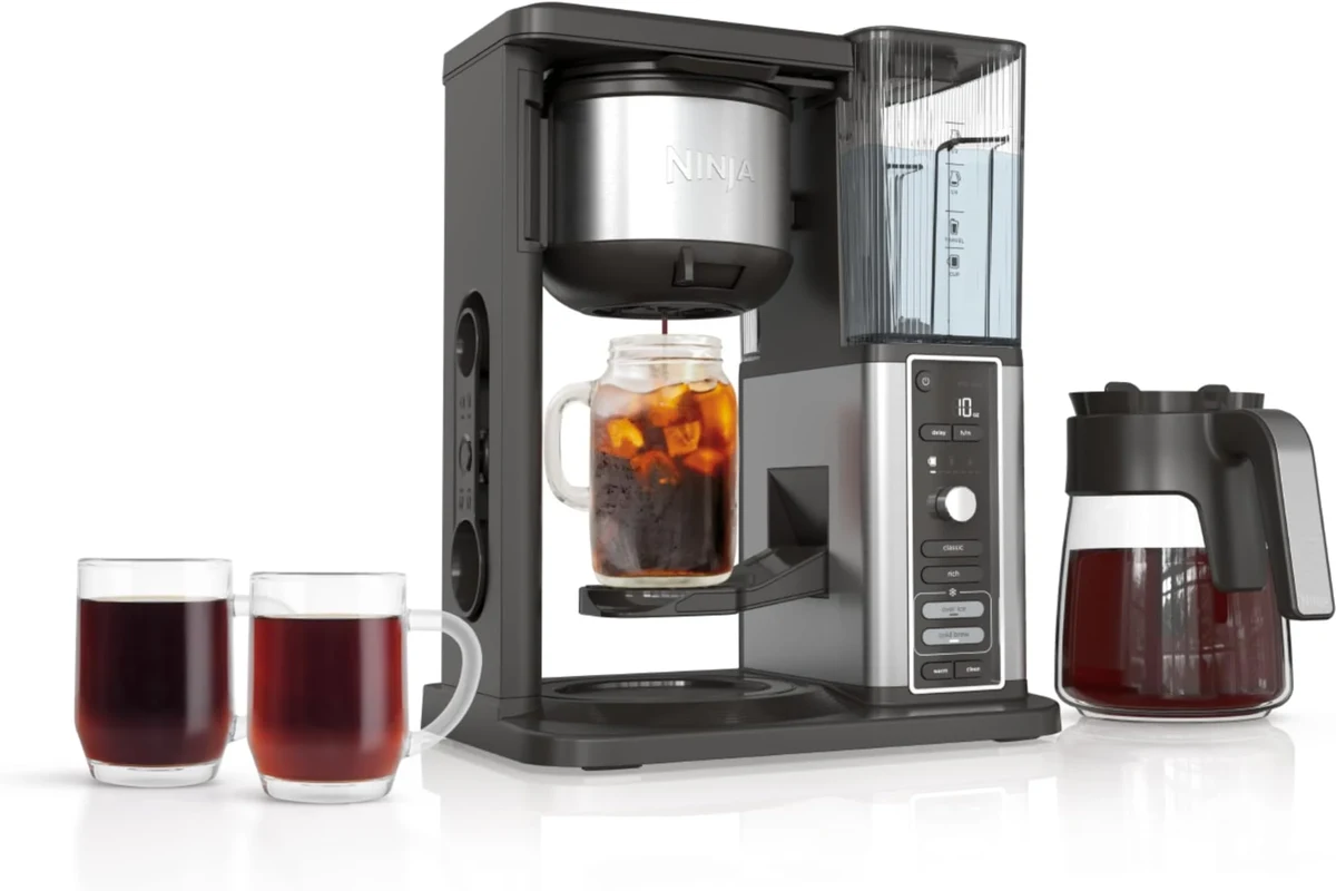 Cold brew coffee maker with steeped coffee, filter, and glass jar in a home kitchen