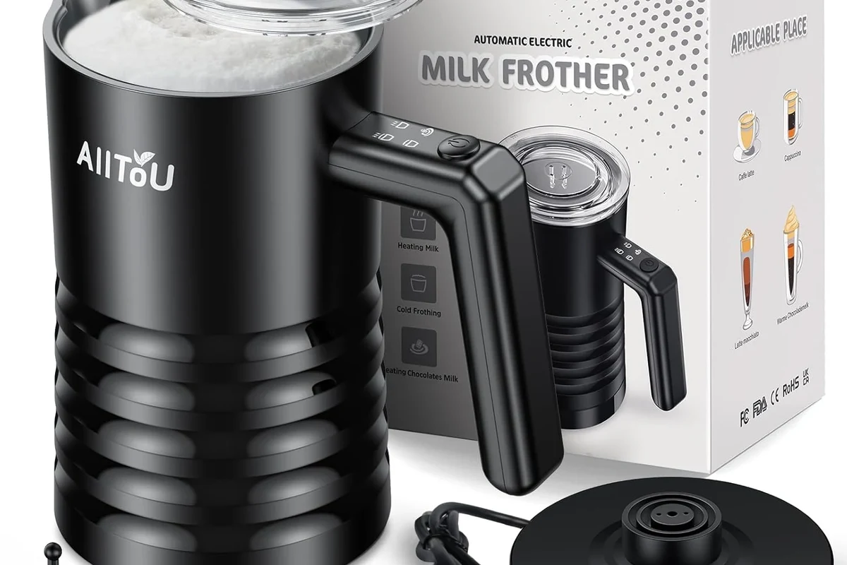 Milk frother heating and foaming milk in a kitchen countertop pitcher