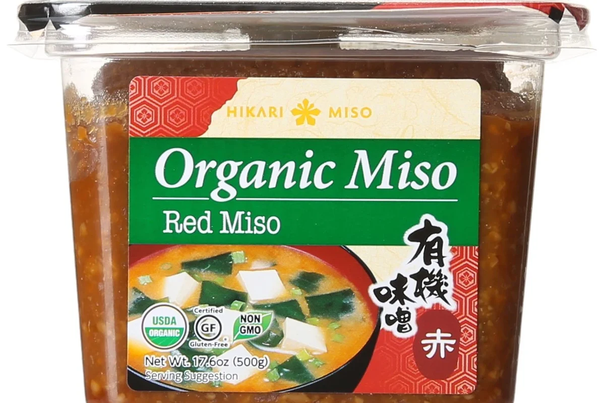 Jar of miso paste with bowls of soup ingredients in a home kitchen