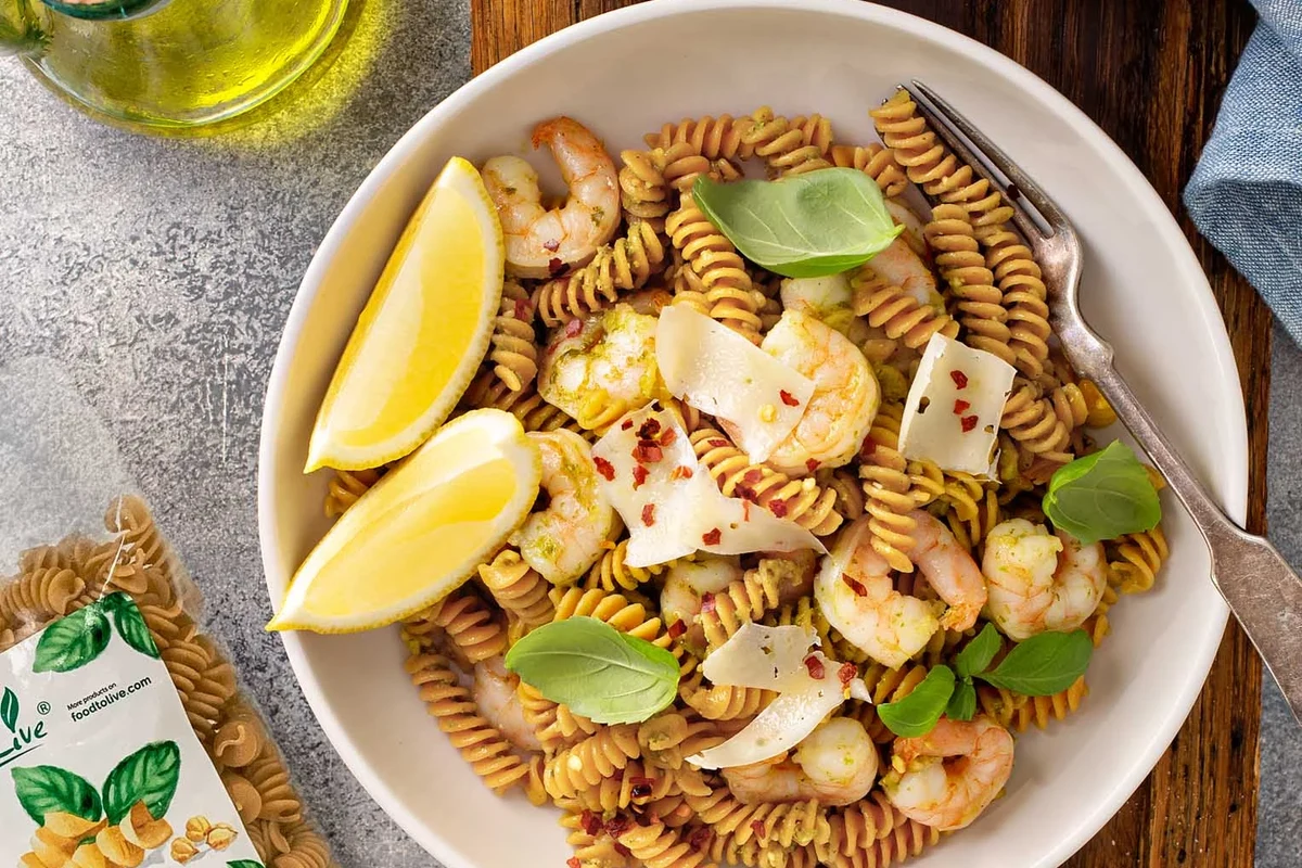 Organic pasta, whole wheat pasta, and fresh vegetables arranged in a bright home kitchen