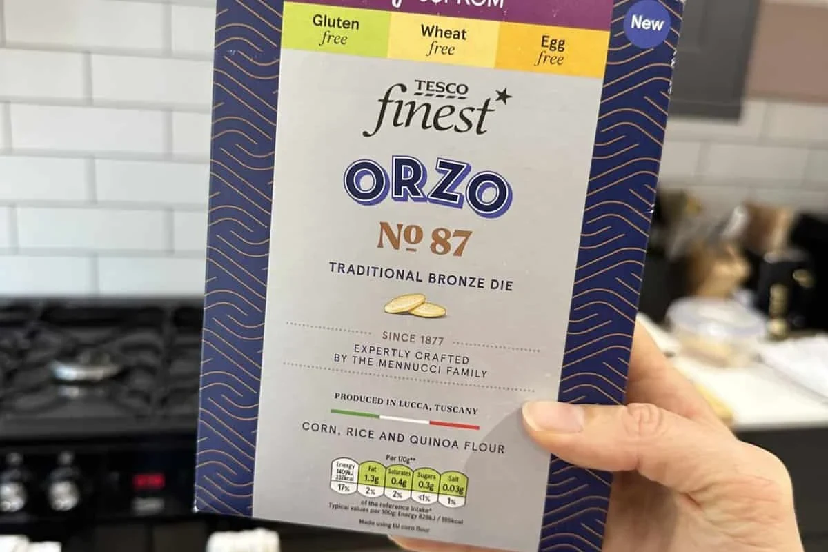 Bowl of orzo pasta with a side note about gluten free options in a home kitchen