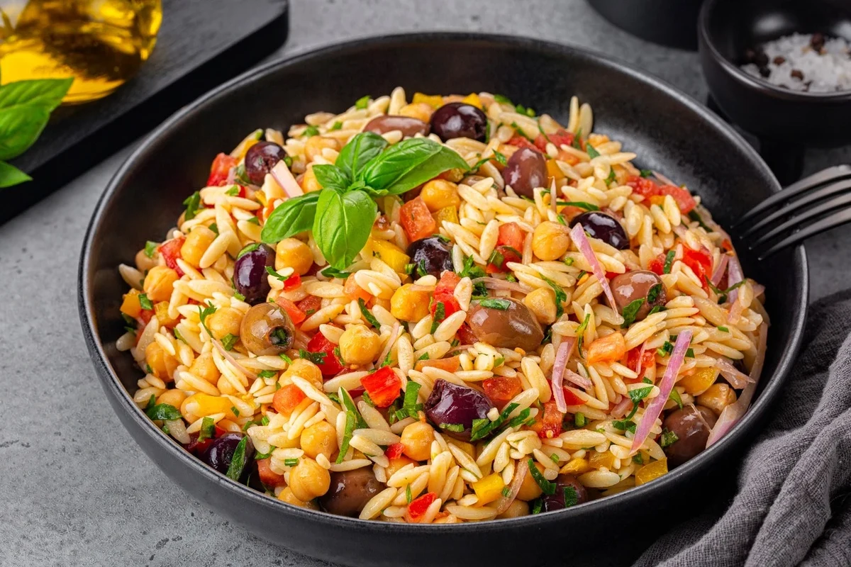 Bowl of plain pasta with mild sauce ingredients on a kitchen counter