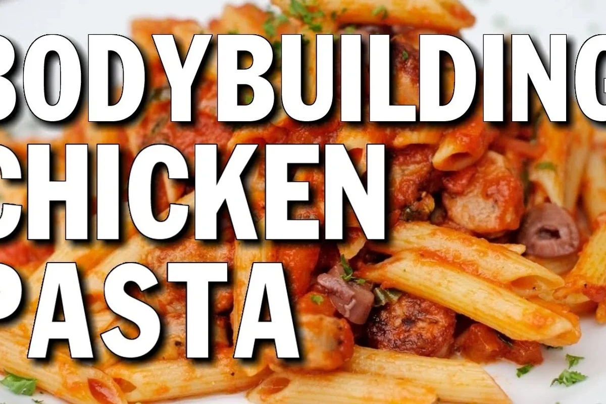 Bowl of pasta with chicken, tomato sauce, and vegetables on a kitchen table