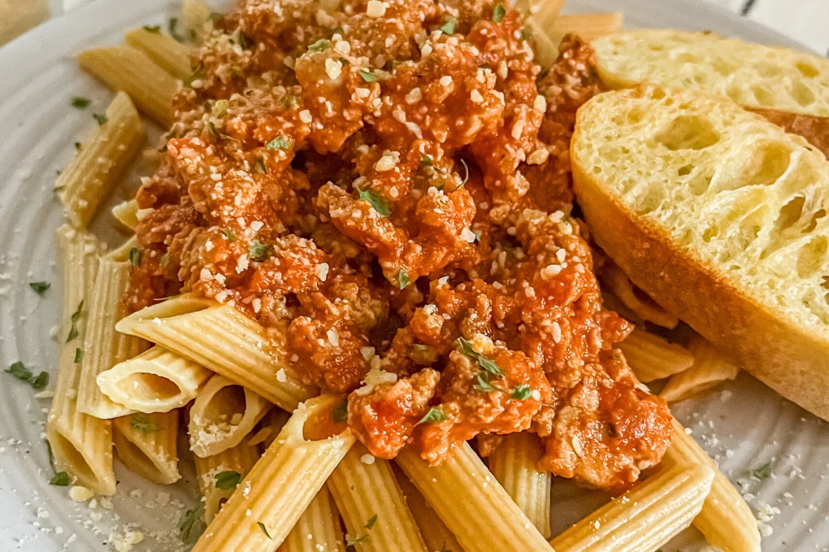 Bowl of pasta with vegetables and grilled chicken on a kitchen table for a diabetes-friendly meal
