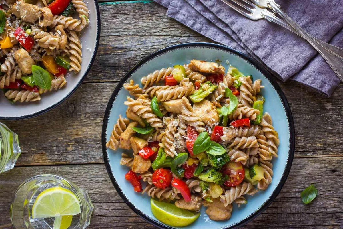 Bowl of pasta with vegetables and protein in a bright home kitchen
