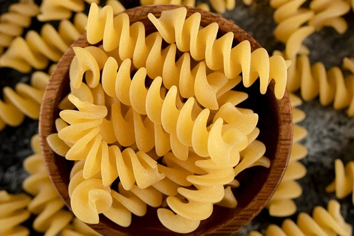Bowl of pasta with vegetables and protein in a bright home kitchen