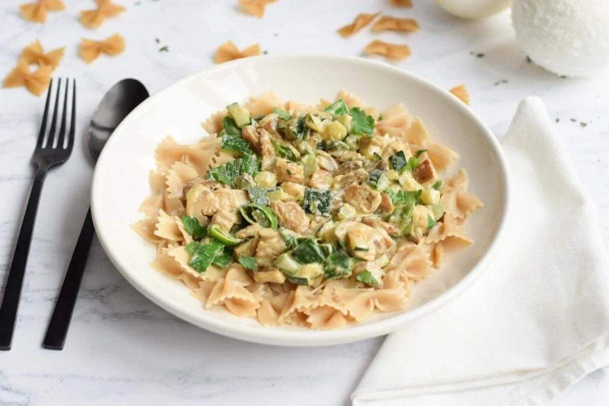 Bowls of simple low FODMAP pasta with rice noodles, tomato sauce, and herbs in a bright kitchen
