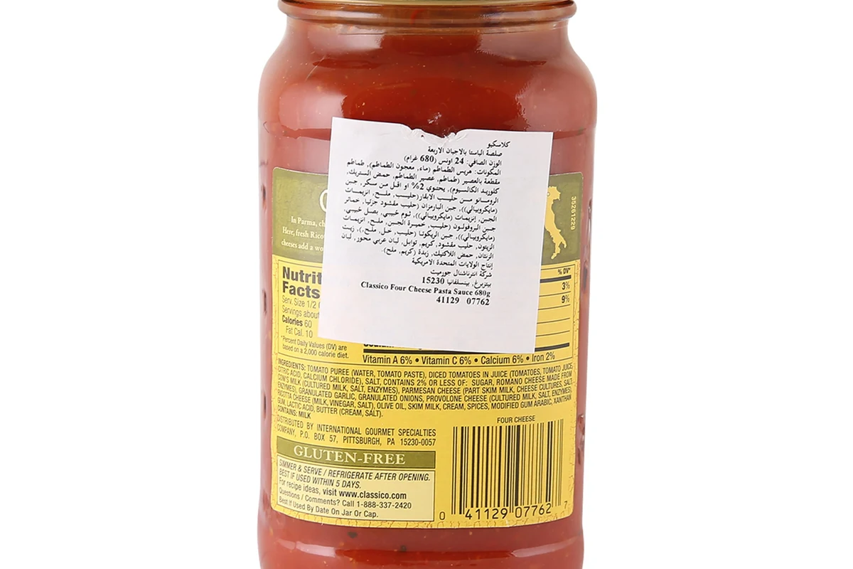 Jar of pasta sauce beside gluten free pasta and fresh tomatoes in a bright kitchen